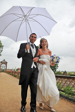Wedding Couple walking at Kenilworth Castle in the rain